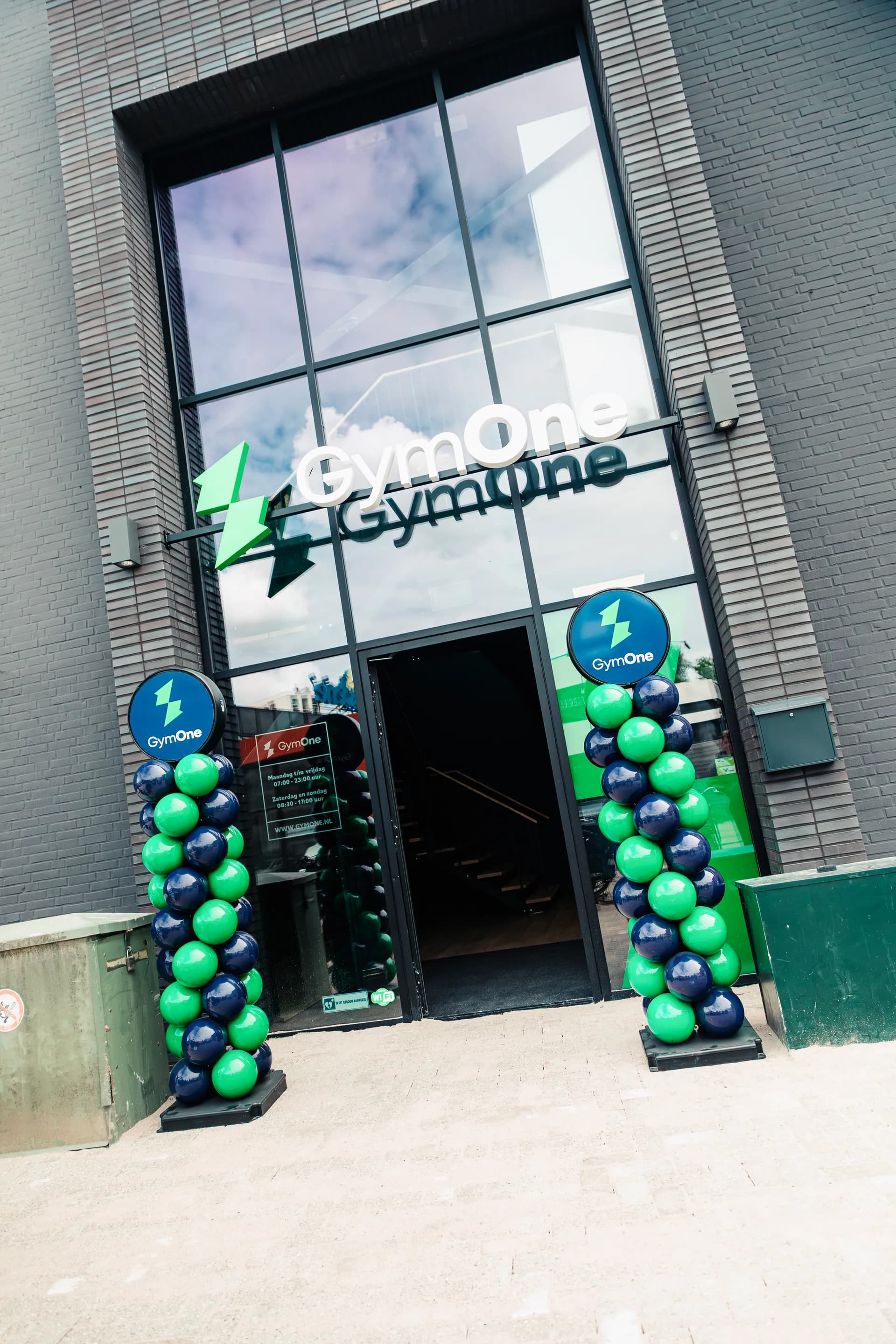 GymOne Haarlem: entree met GymOne-logo en ballonbogen bij de opening