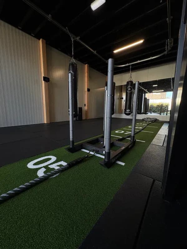 Sledpush-rig op kunstgras-baan met chains, klaar voor HYROX-training